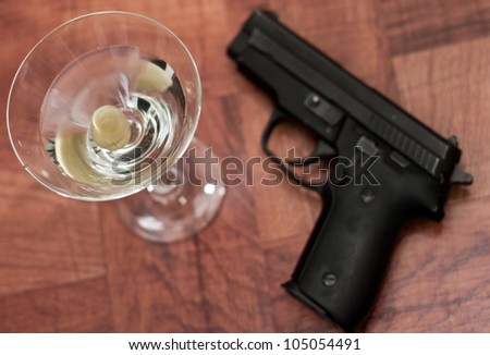 closeup of a martini on a bar top with an out of focus gun