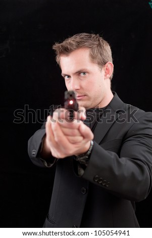 young male pointing with an out of focus gun with a laser