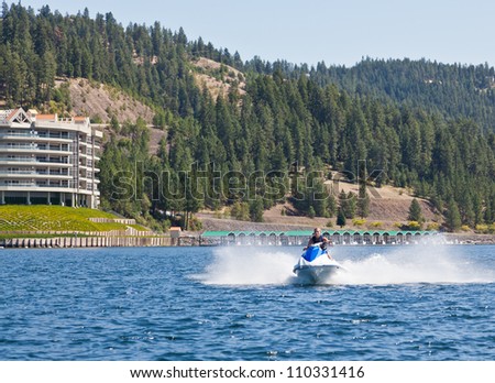 Beautiful woman out on the lake riding a wave runner on bright sunny day