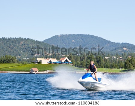 Beautiful woman out on the lake riding a wave runner on bright sunny day