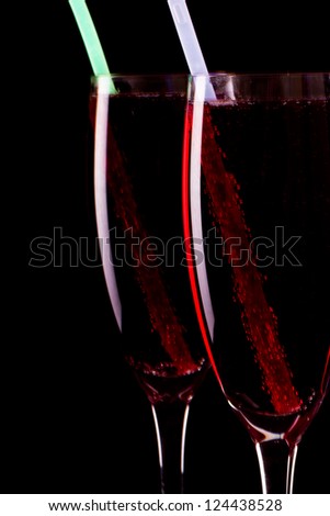 champagne flutes isolated on a black background, dark setting with glow sticks