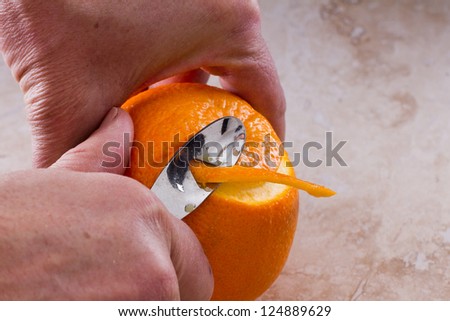 making a cocktail garnish from an orange, orange twist