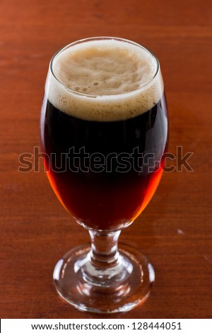 black and tan, half stout half red ale on a bar top