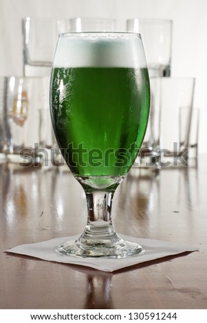 St. Patrick\'s day green beer served in a chalice on a busy bar