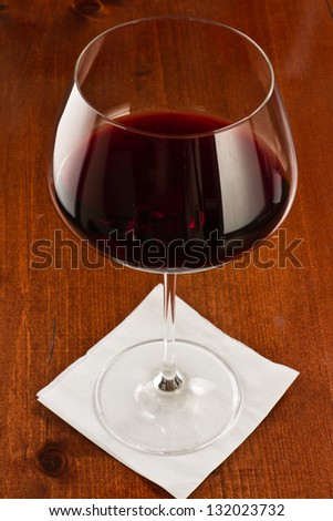 long stem wine glass with red wine served on a bar top
