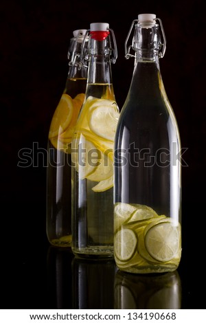 citrus infused vodka in bottles isolated over a black background