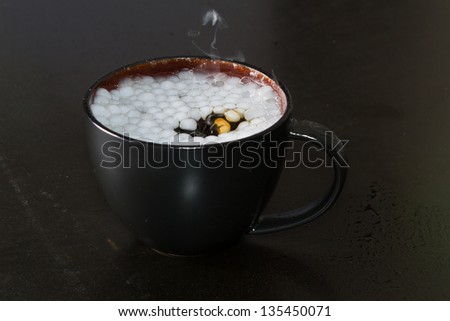 closeup of a cup with smoke and bubbles in a dark setting