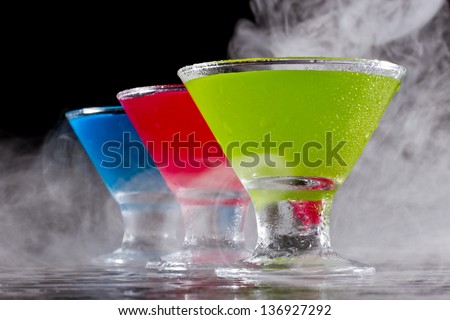 bright mini martinis served on a wet dark bar top with fog for a dramatic effect
