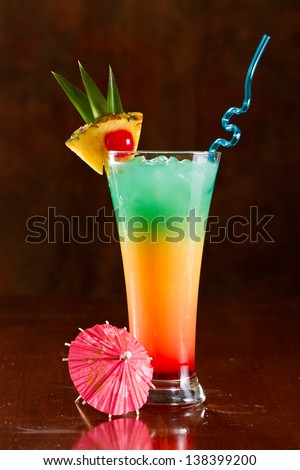 colorful tropical cocktail with layers and fruit garnishes