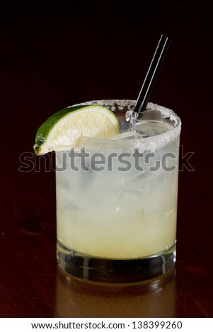 fresh lime juice margarita served on the rocks in a dark restaurant