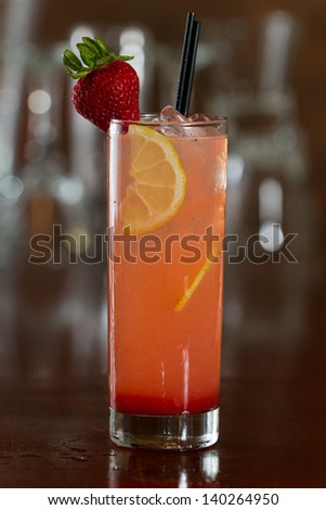 strawberry lemonade served with vodka in a busy out of focus bar