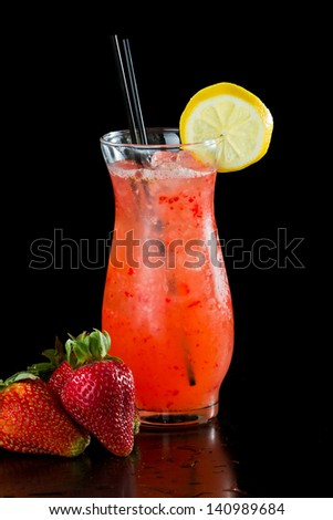 strawberry lemonade isolated on a black background garnished with a lemon wheel