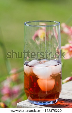 ice tea served outside with a natural green and flower garden in the background