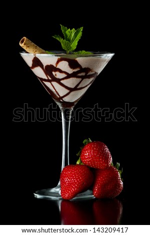 chocolate martini served isolated on a black background with chocolate swirl and a wafer stick