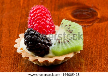 bite size fruit tarts with fresh fruit served on a table