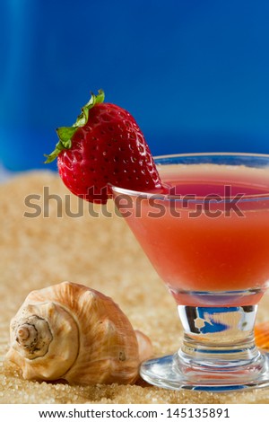closeup of a strawberry martini served on the beach