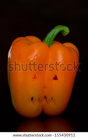 hand carved orange bell pepper for halloween set on a dark background