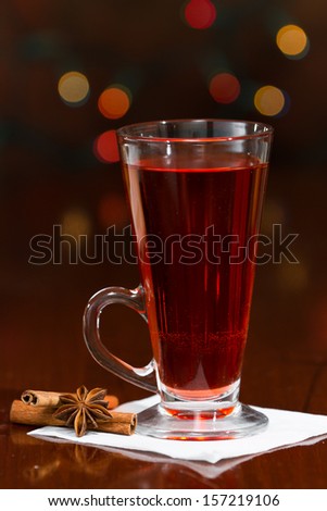 christmas morning tea served in a tall clear glass with spices and a red table cloth