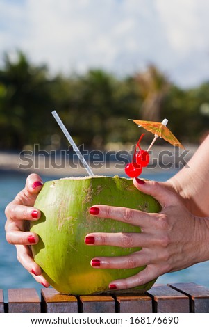 coconut drink served in a green coconut with rum and juices served on the beach of Belize