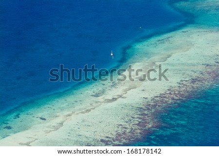 aerial view of the barrier reef of the coast of San Pedro, Belize. with large waves breaking away from the coast