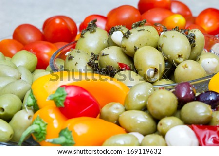 close up of a platter with different olives and vegetables with oil and seasoning