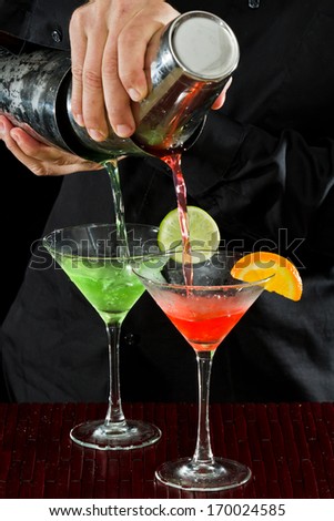 professional bartender pouring two martinis at the same time in  a fluid motion