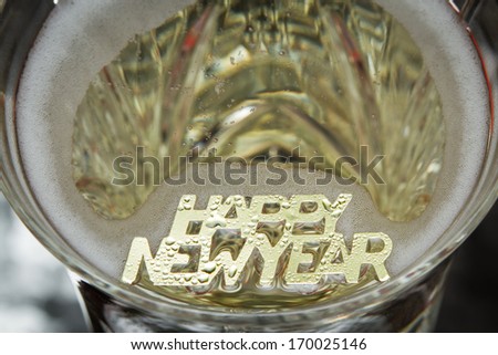 happy new year in golden letters floating in champagne
