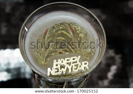 happy new year in golden letters floating in champagne