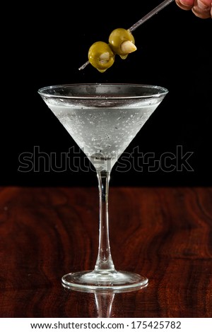 Garlic stuffed martini olives garnishing a sparking vodka martini