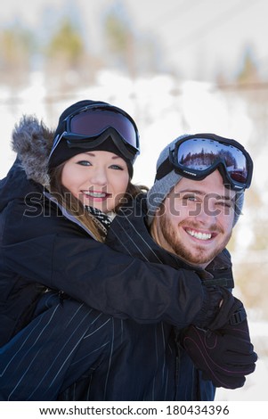 beautiful young couple wearing snow gear playing outside on the snowy mountains of northern Idaho