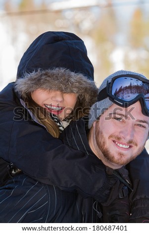 beautiful young couple wearing snow gear playing outside on the snowy mountains of northern Idaho