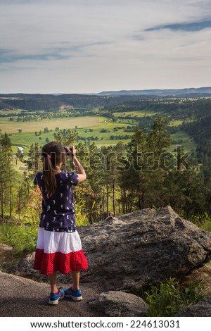 Devils Tower National Monument, Wyoming - July 03 : Young patriot photographing the valley from a viewpoint on the mountain loop trail; July 03 2014 in Devils Tower National Monument, Wyoming