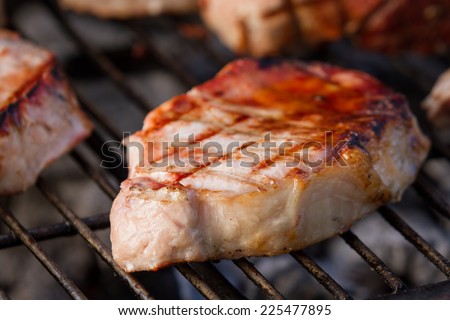 grilling pork tenderloins seasoned with sea salt and spices on an outdoor grill