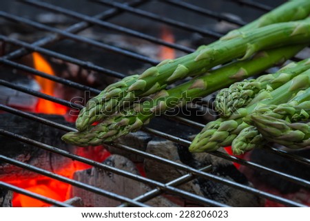 grilled asparagus on an outdoor grill with open flame