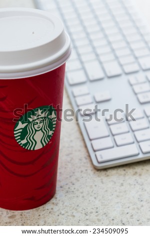Hurricane Utah - November 29 : photo of a holiday Starbucks cup next to a computer keyboard, November 29 2014 in Hurricane, Utah