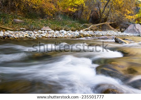 beautiful serene river landscape in autumn with white water over rocks in Zion National Park, Utah
