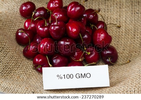 food labeling concept with bright red cherries and a GMO label