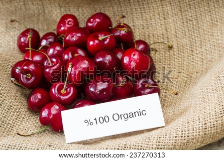 food labeling concept with bright red cherries and an organic label