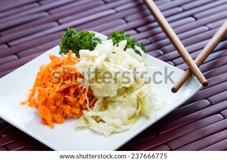 serving of home mad fermented or cultured vegetables served on a white plate with chopsticks