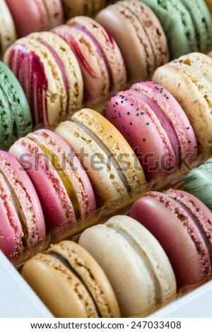 close up of a box with a variety of home made french macaroons with pastel colors