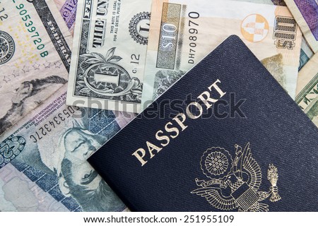 american passport on top of multinational currencies on a white background