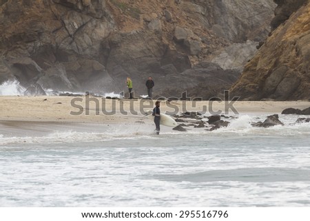 Pfeiffer Beach, California - May 01 : Male surfer in a full suit surfing on the cold waves of the California coast, May 01 2015 Pfeiffer beach, California.