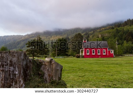 little red school house in a green meadow of northern California
