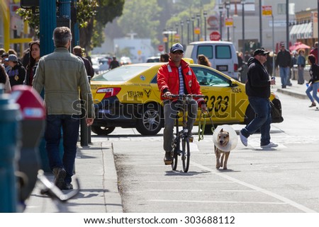 San Francisco, California - May 11 : Busy lifestyle in San Francisco, a man walking his recovering dog on the street, May 11 2015 San Francisco, California.