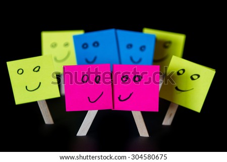 sticky notes with hand drawn faces over a black background for a concept of same sex marriage