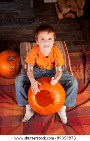 young cross eyed boy carving pumpkins for halloween