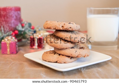 Chocolate chip cookies and milk as a center piece for a christmas scene on a golden place mat