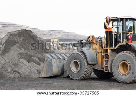 female construction worker with a front loader machine