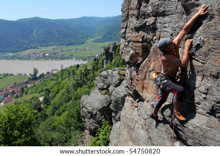 Male rock-climber  on a granite wall above the river