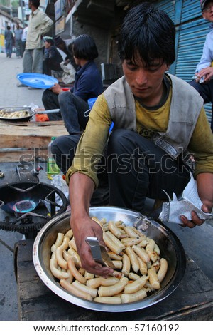 KARGIL, INDIA - AUGUST 19: Man selling fried sausages in the streets of Kargil, North India August 19, 2008 in Kargil, India
